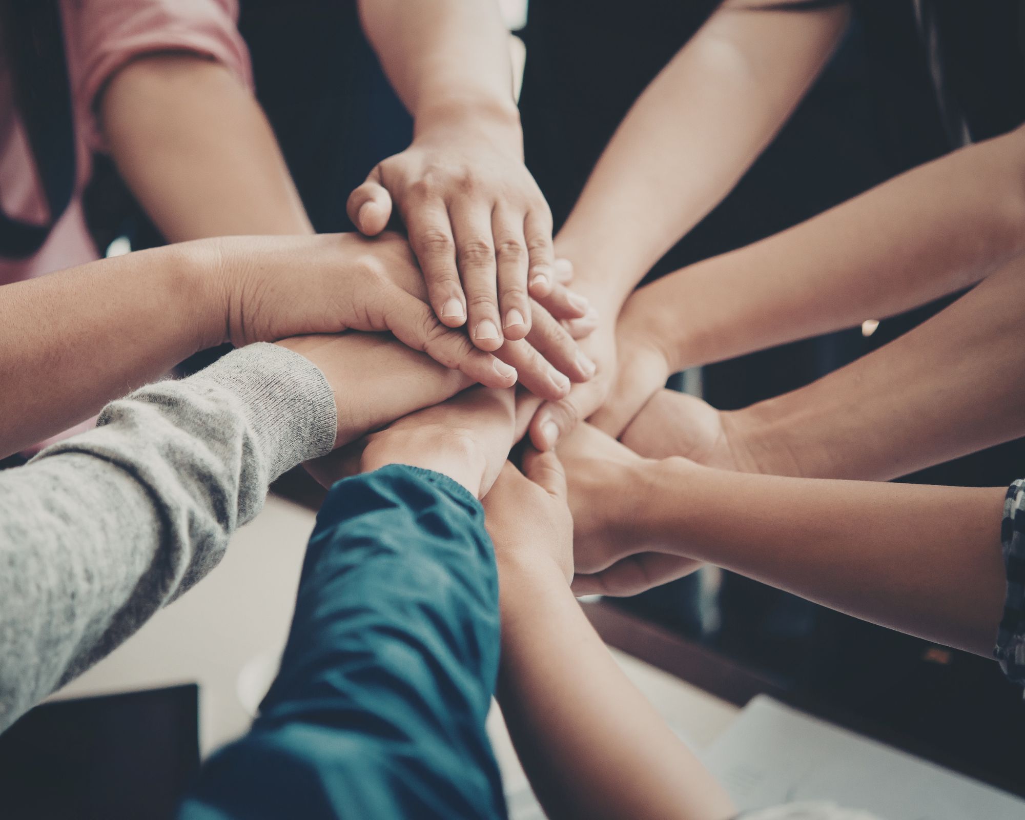 Handen van een groep mensen op elkaar gestapeld
