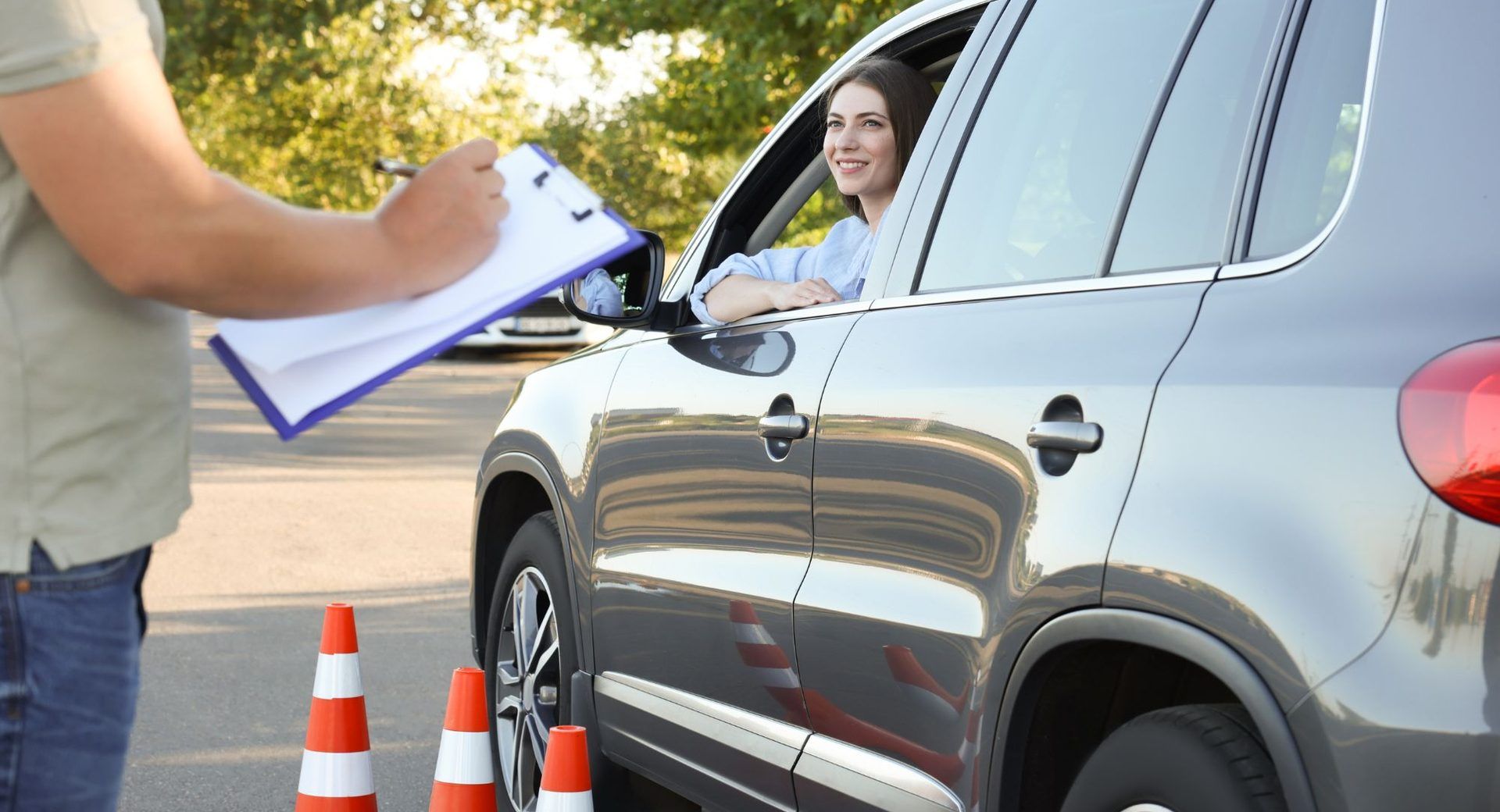 Instructeur met klembord naast een leerling in de lesauto van Sure to Pass